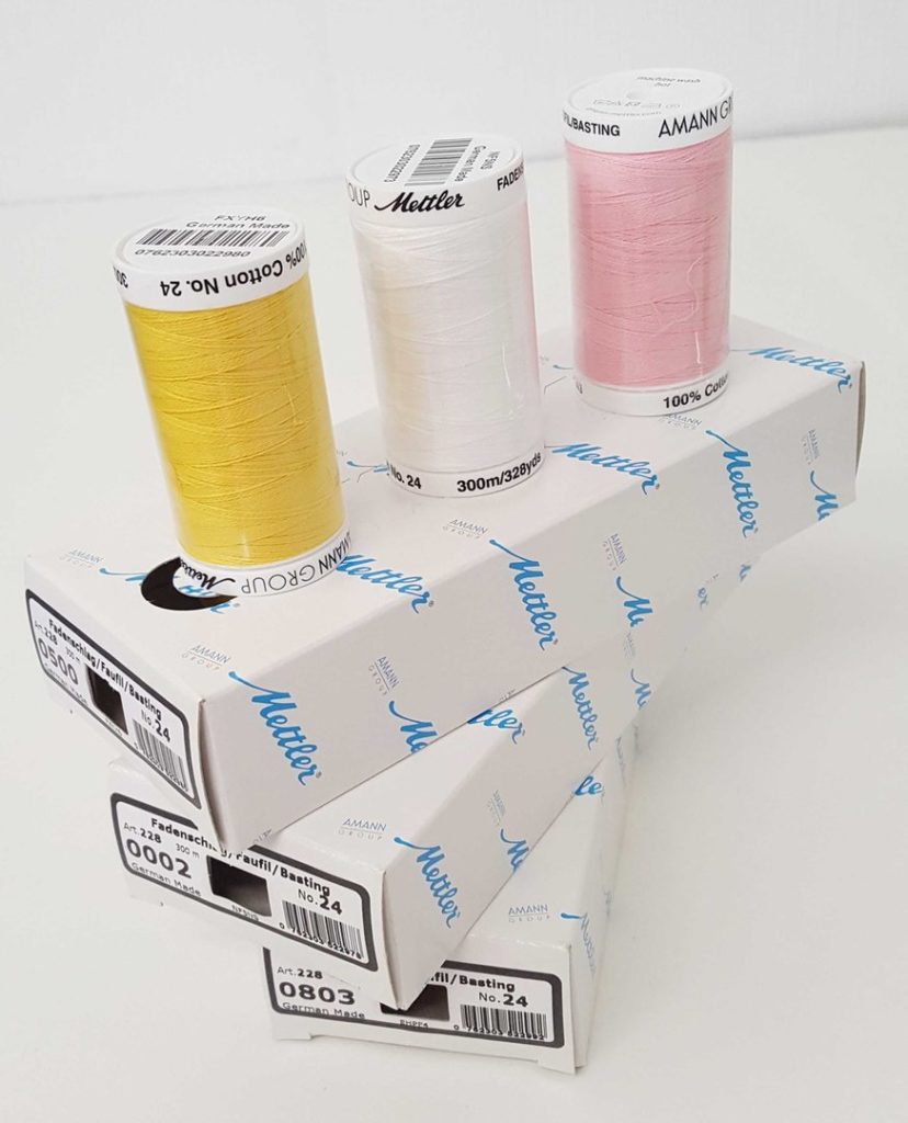 Basting thread by Amann Mettler white, yellow and pink
